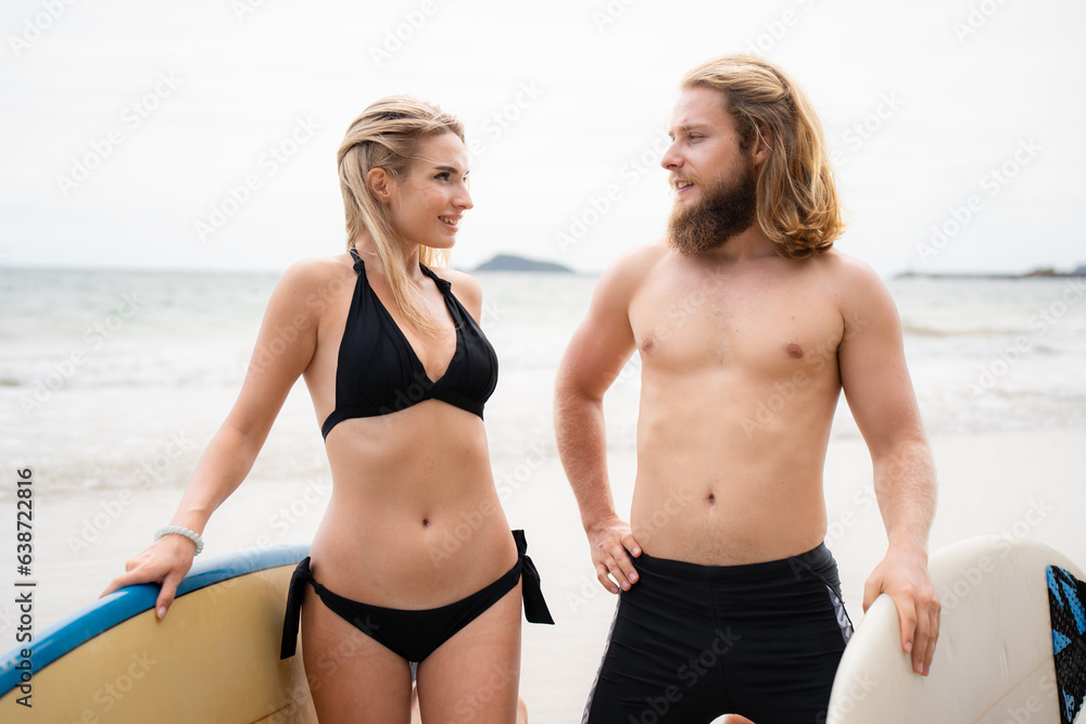 Young couple of surfers with surfboard on the beach Young couple of surfers with surfboard on the beach
