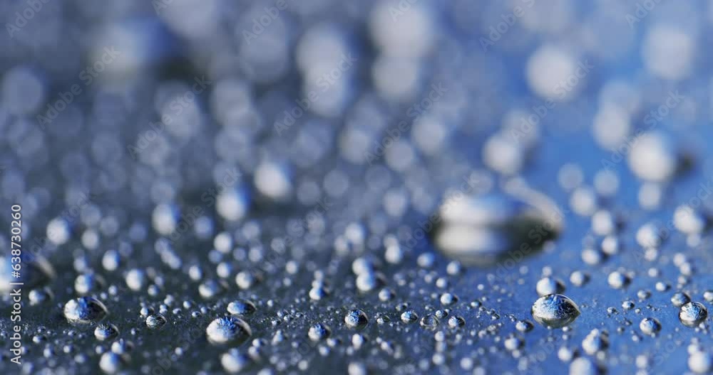 Micro video of close up of water drops with copy space on blue background Micro video of close up of water drops with copy space on blue background