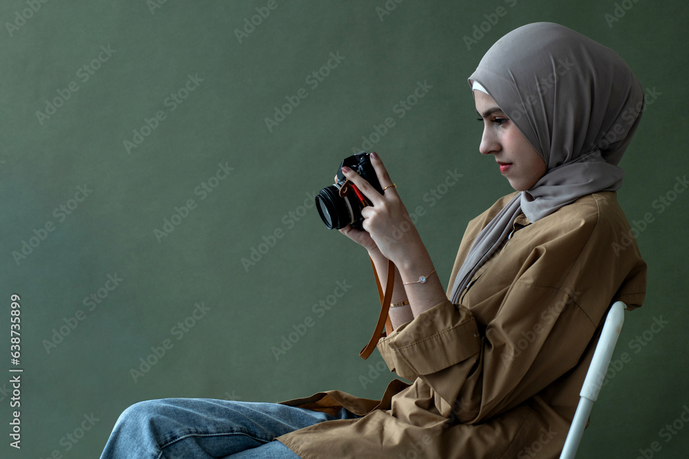Pretty Muslim girl in hijab holding vintage camera over background in ...