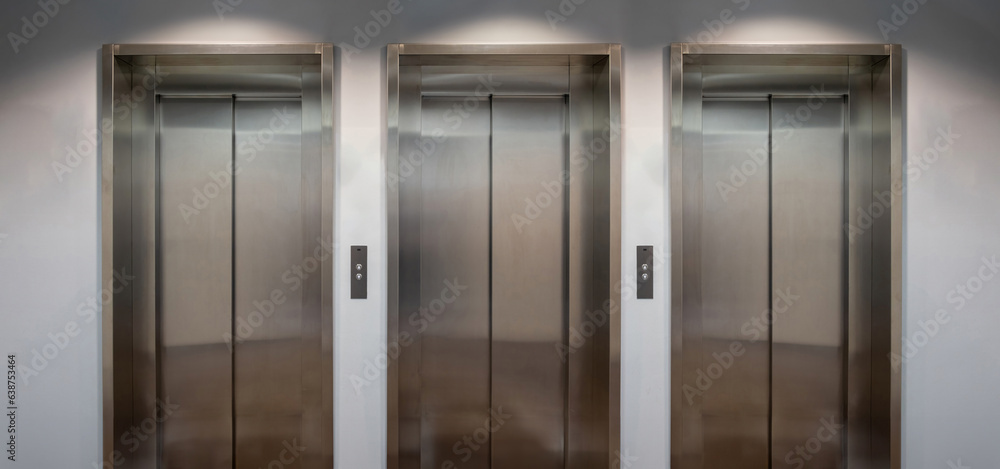Elevators lobby, Stainless steel lifts with closed doors front view.