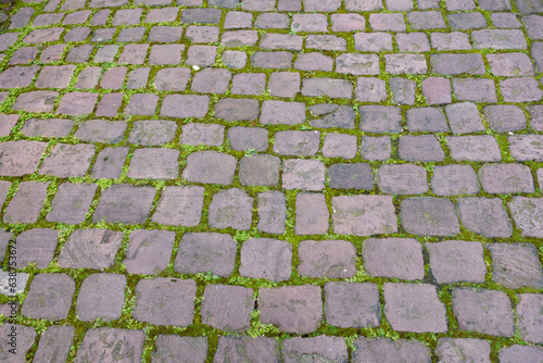 Stone paved floor background texture. Cobblestone grey footpath above view