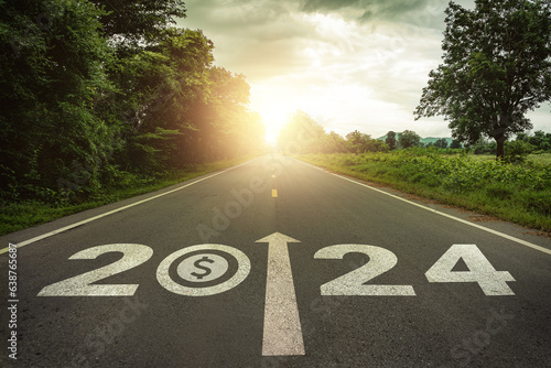 New year 2024 and business performance target concept. Dollar money symbol and text 2024 written on the road at sunset. Concept of planning, challenge, business strategy, opportunities, performance.