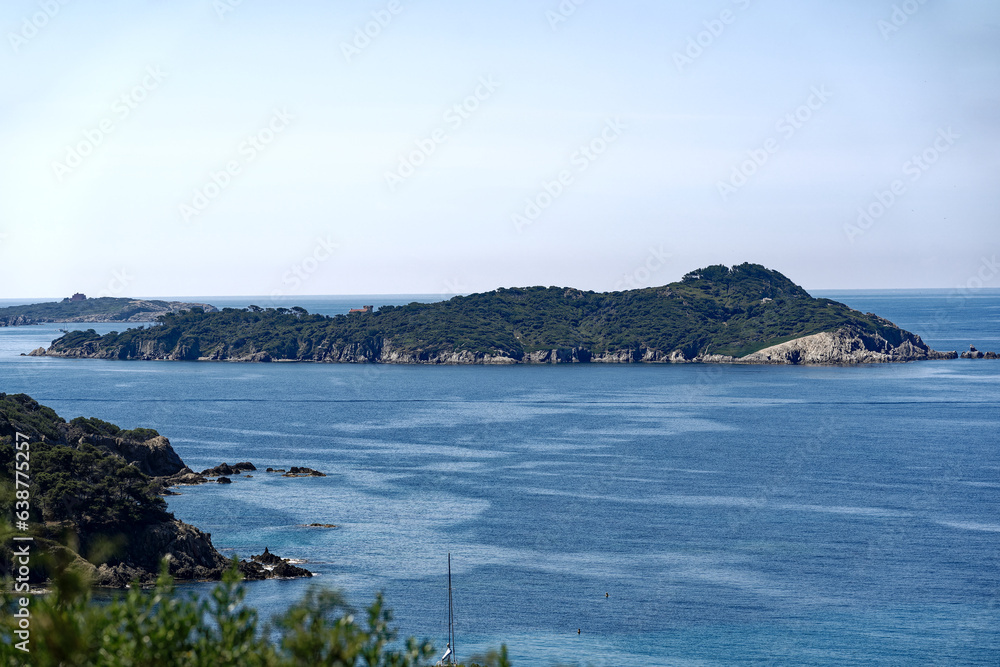 Scenic view of Mediterranean sea with island and woodland seen from viewpoint at village of Giens on a sunny late spring day. Photo taken June 8th, 2023, Giens Peninsula, Hyères, France.