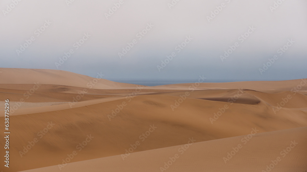 Peaceful view across the top of the sand dunes with the sky and Atlantic Ocean in the background, Namibia
