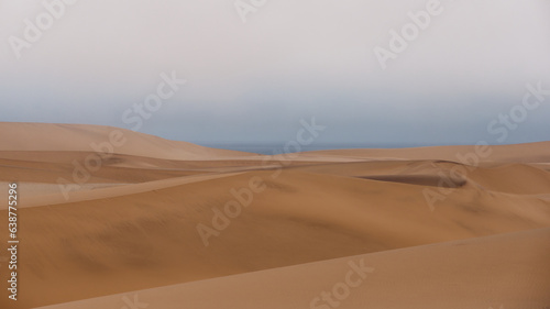 Peaceful view across the top of the sand dunes with the sky and Atlantic Ocean in the background  Namibia