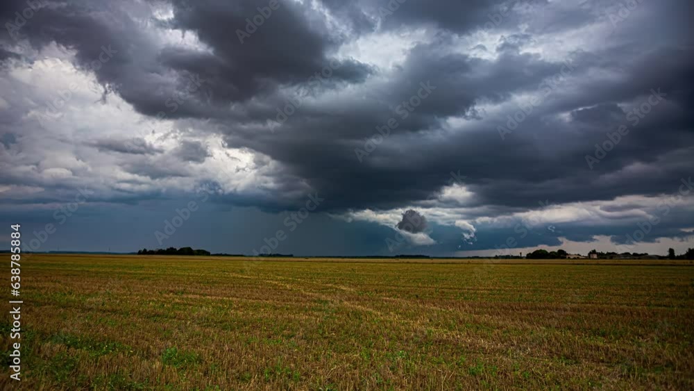 Dark, stormy, dramatic thundercloud cloudscape over farmland fields - time lapse