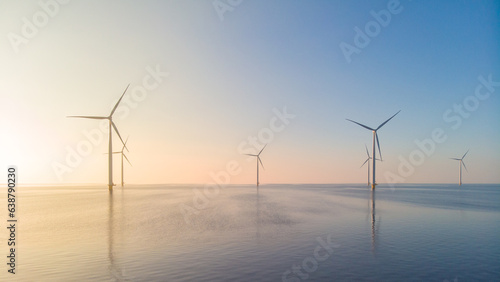 offshore windmill park, windmill park in the ocean aerial view with wind turbine Flevoland Netherlands Ijsselmeer. Green energy during sunset