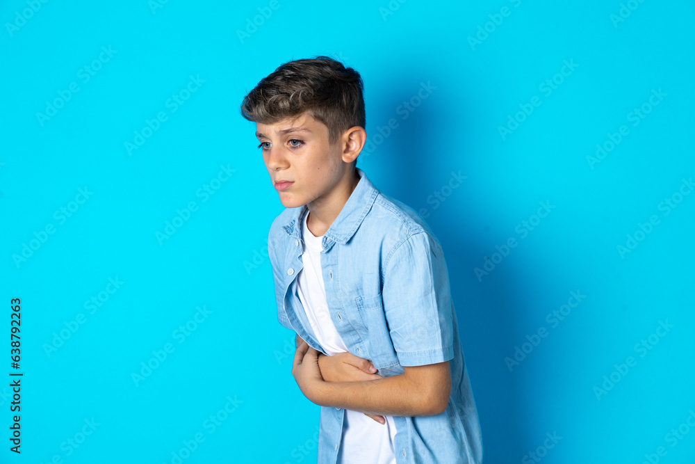 Beautiful kid boy wearing casual clothes got stomachache Beautiful kid boy wearing casual clothes got stomachache