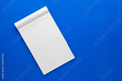 Top view of a open notebook on a blue background, school notebooks with a spiral spring, office notepad flat lay