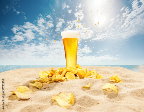Glasses of foamy, chill, lager beer with chips appetizers on sand against ocean and blue sky background. Concept of beer, brewery, holidays and vacation, traditions, festival, alcohol drink, ad