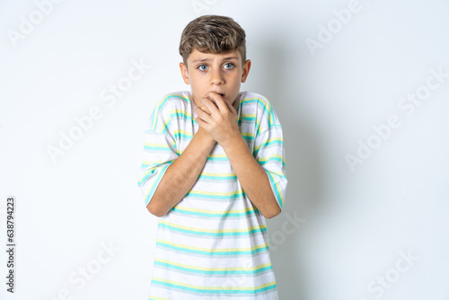 Foto Beautiful kid boy wearing striped casual t-shirt holding oneself, feels very col