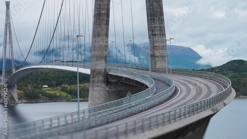 Cars and trucks pass along the curves of the Halogaand Bridge above the fjord. Tight parallax shot. photo