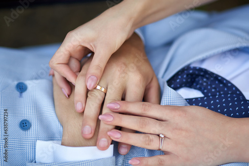Close-up of hands of newlyweds with rings holding each other