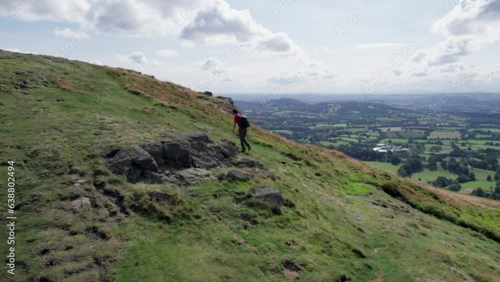 Hiker Backpacker walking in Malvern Hill and the Great Malvern Town, Area of Outstanding Natural Beauty, UK. Summer Hike Hiker Backpacker walking in Malvern Hill and the Great Malvern Town, Area of Outstanding Natural Beauty, UK. Summer Hike