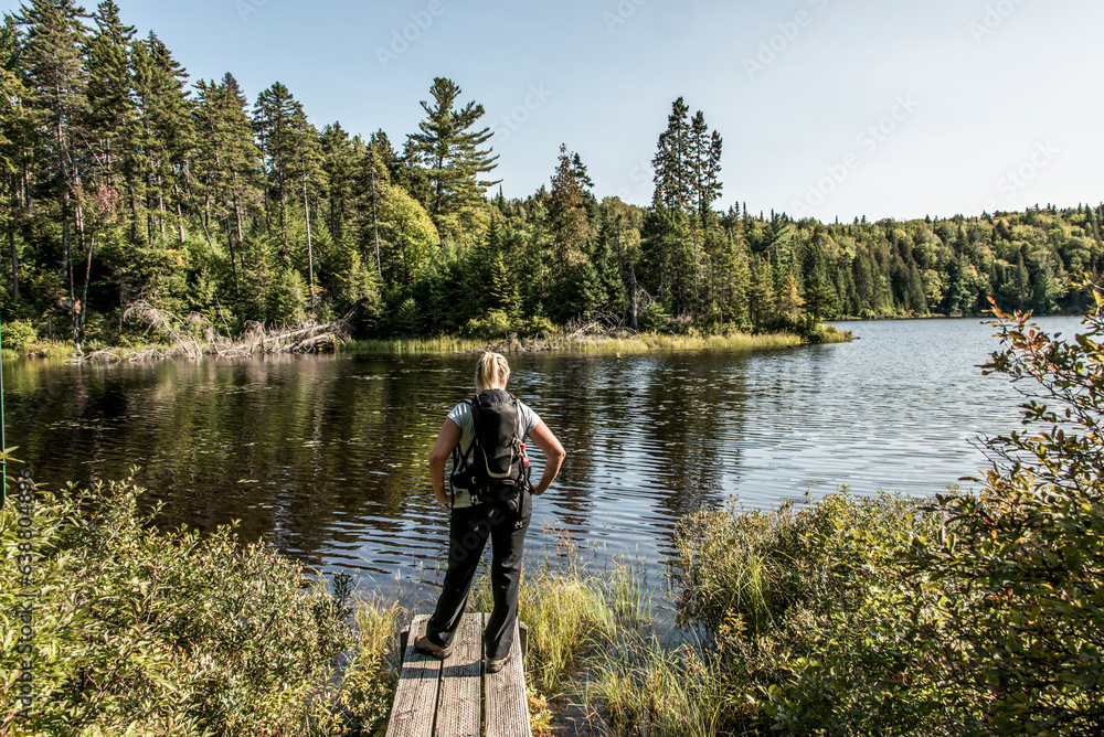 Girl hiking in the Forest near lake in La Mauricie National Park Quebec, Canada on a beautiful day