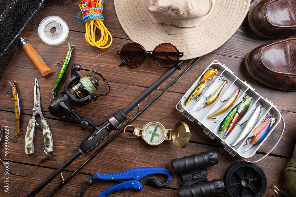 Fishing rod, tackles and other stuff for recreation activity on the wooden desk. Fishing season concept Fishing rod, tackles and other stuff for recreation activity on the wooden desk. Fishing season concept