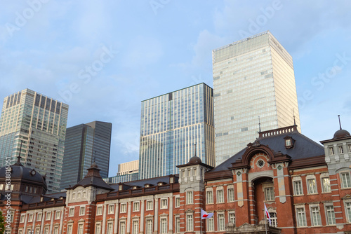 Facade of red brick Tokyo central station with modern high buildings