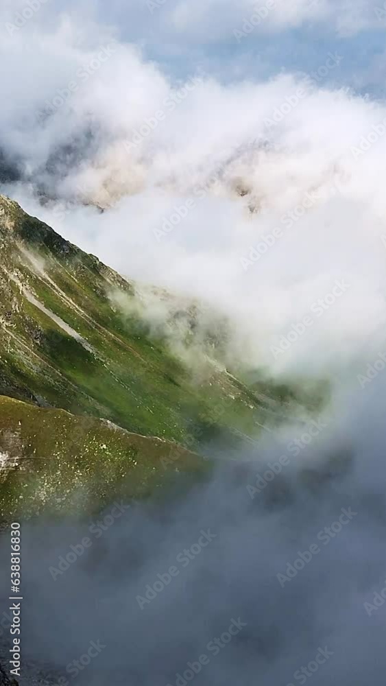 clouds on the right moving slowly up a green mountain slope to the left in the south tyrol alps in a slow-motion manner clouds on the right moving slowly up a green mountain slope to the left in the south tyrol alps in a slow-motion manner
