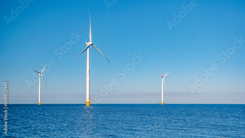 offshore windmill park with clouds and a blue sky, windmill park in the ocean aerial view with wind turbine Flevoland Netherlands Ijsselmeer. Green energy production in the Netherlands