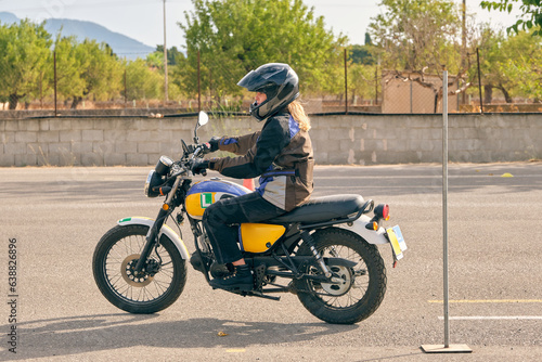 Woman in helmet riding motorcycle on motordrome