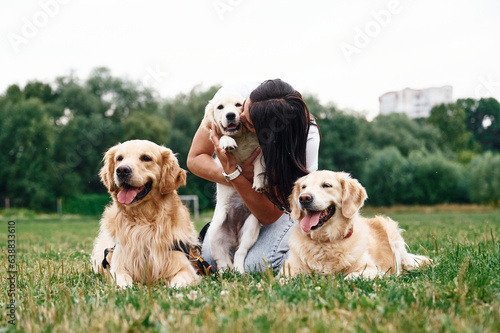 Front view. Woman with beautiful dogs are in the field outdoors