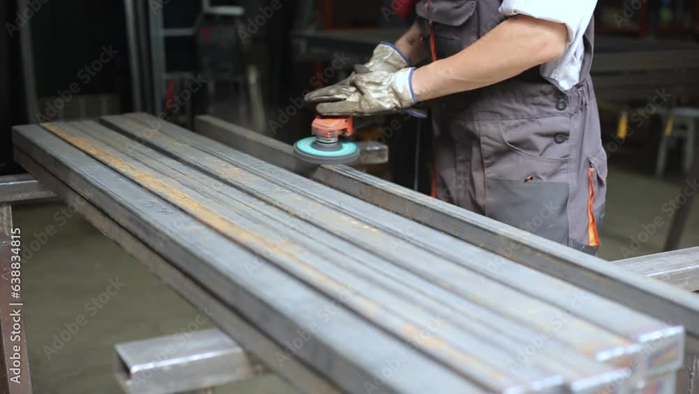 Worker cleaning iron steel pipe profile, deleting rust and other dirt from metal using Angle Grinder Coral Disc. industry concept. worker in uniform and safe gloves on hand. Worker cleaning iron steel pipe profile, deleting rust and other dirt from metal using Angle Grinder Coral Disc. industry concept. worker in uniform and safe gloves on hand.