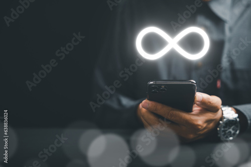 Принти на полотні Businessman showcasing smartphone with infinity symbol, symbolizing unlimited connection in data technology, future unlimited