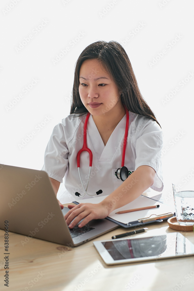 Asian physician browsing laptop in clinic Asian physician browsing laptop in clinic
