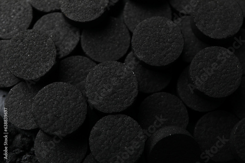Pile of black activated charcoal pills close-up photo