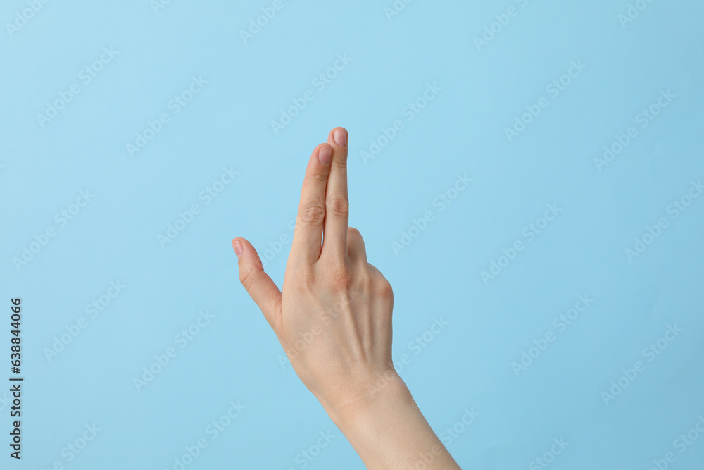 Female well-groomed hand on a light blue background Female well-groomed hand on a light blue background