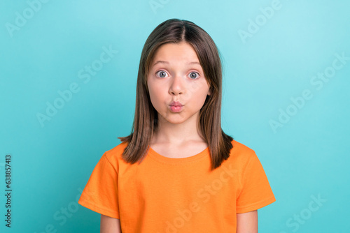 Portrait of friendly schoolgirl with straight hairdo dressed orange t-shirt pouted lips send kiss isolated on turquoise color background