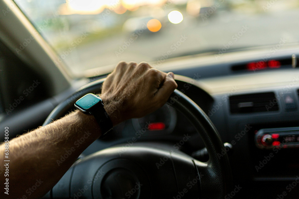 driving a car, the driver's hands on the steering wheel on a sunny day with a smart watch. driving a car, the driver's hands on the steering wheel on a sunny day with a smart watch.