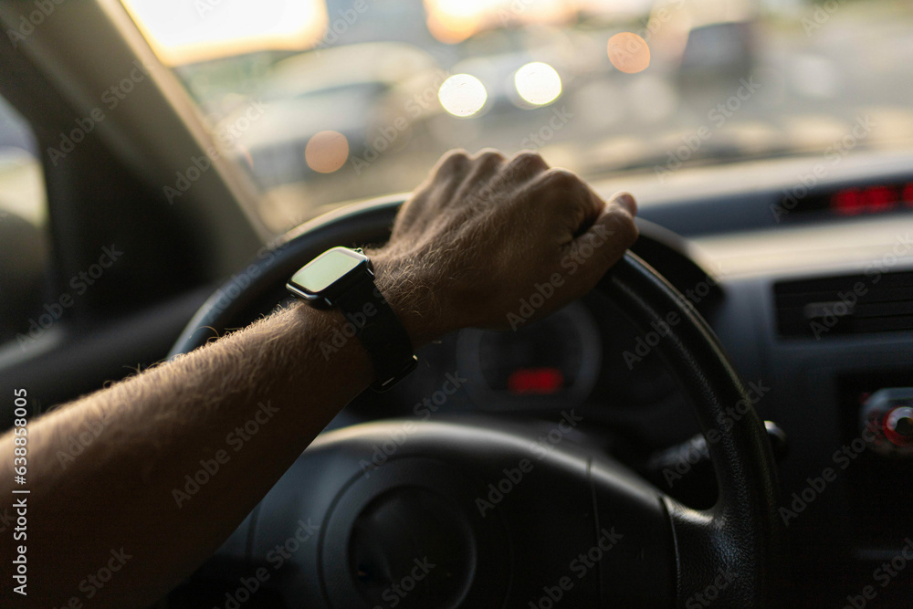 custom made wallpaper toronto digitaldriving a car, the driver's hands on the steering wheel on a sunny day with a smart watch.