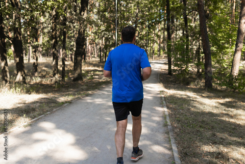 Young Man Running In Wooded Forest - Training And Exercising For Trail Run Marathon Endurance - Fitness Healthy Lifestyle Concept