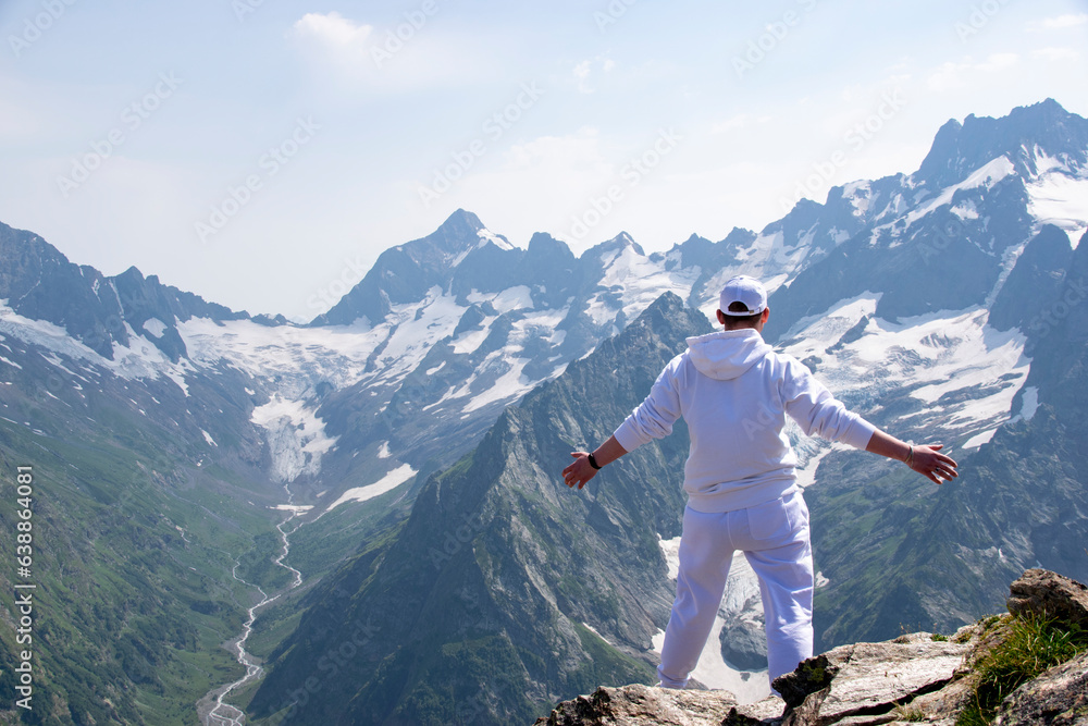 hiker with outstretched arms against the backdrop of mountains, freedom and happiness, achievement in mountains