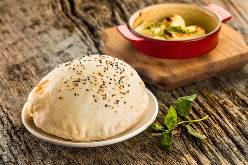 Baked puffed lavash bread on a plate
wooden background
