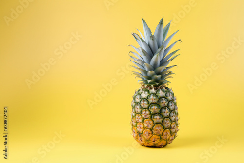 Pineapple fruit on a solid color background. Isolated object in photo studio. Commercial shot with copyspace.