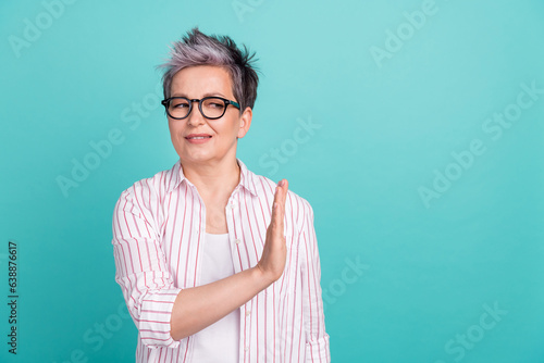 Photo of young woman taboo gesture hand showing her disagree veto looking empty space prohibition strict isolated on cyan color background