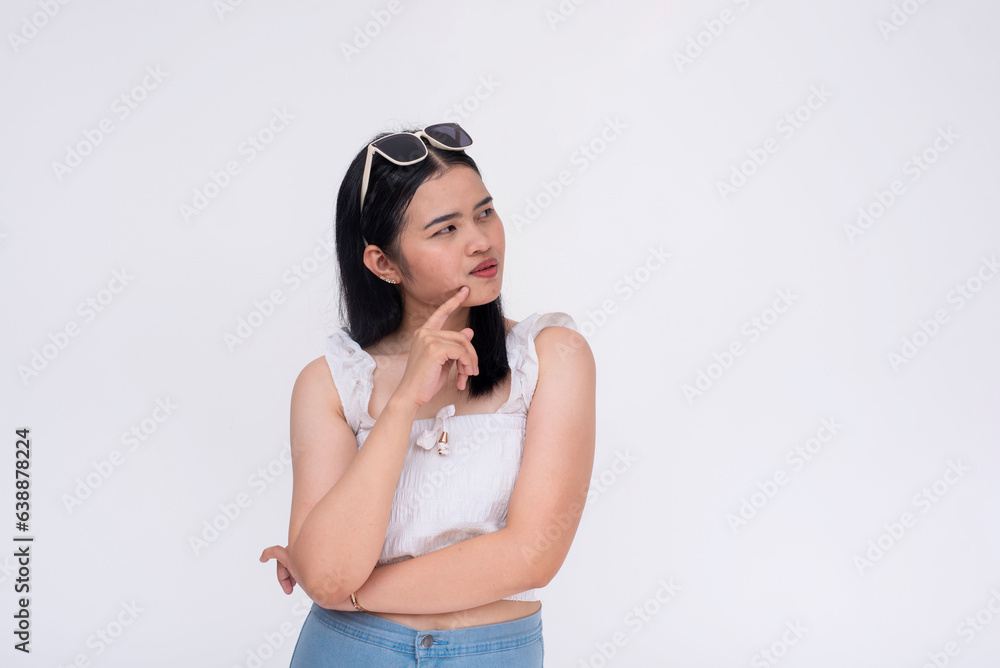 A young asian woman considering her options. A lady in thought looking to the right. Isolated on a white background. A young asian woman considering her options. A lady in thought looking to the right. Isolated on a white background.