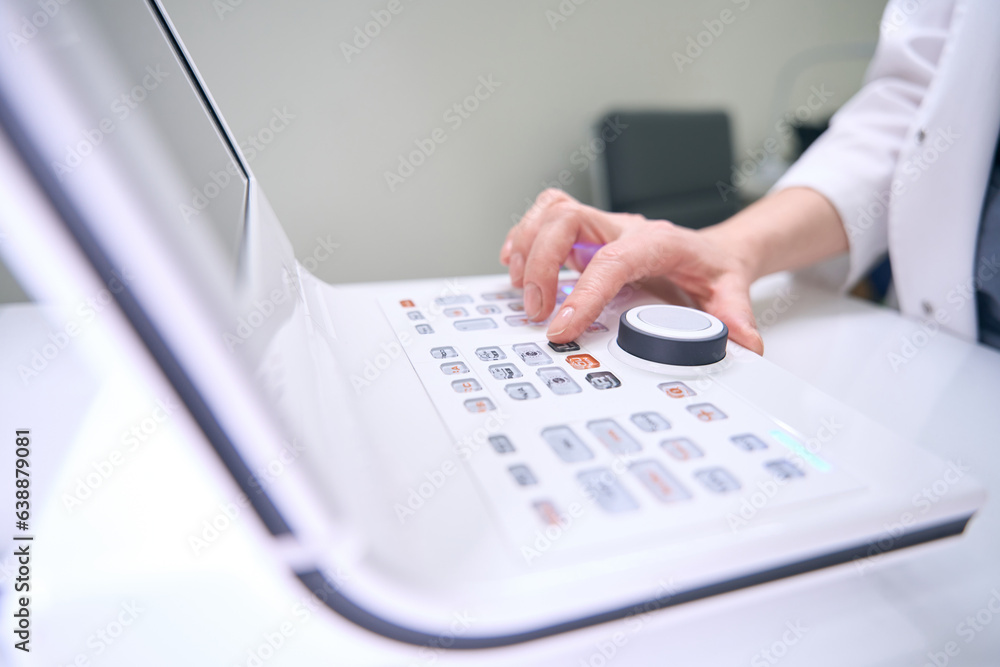 Fototapeta premium Woman ophthalmologist at workplace uses modern equipment