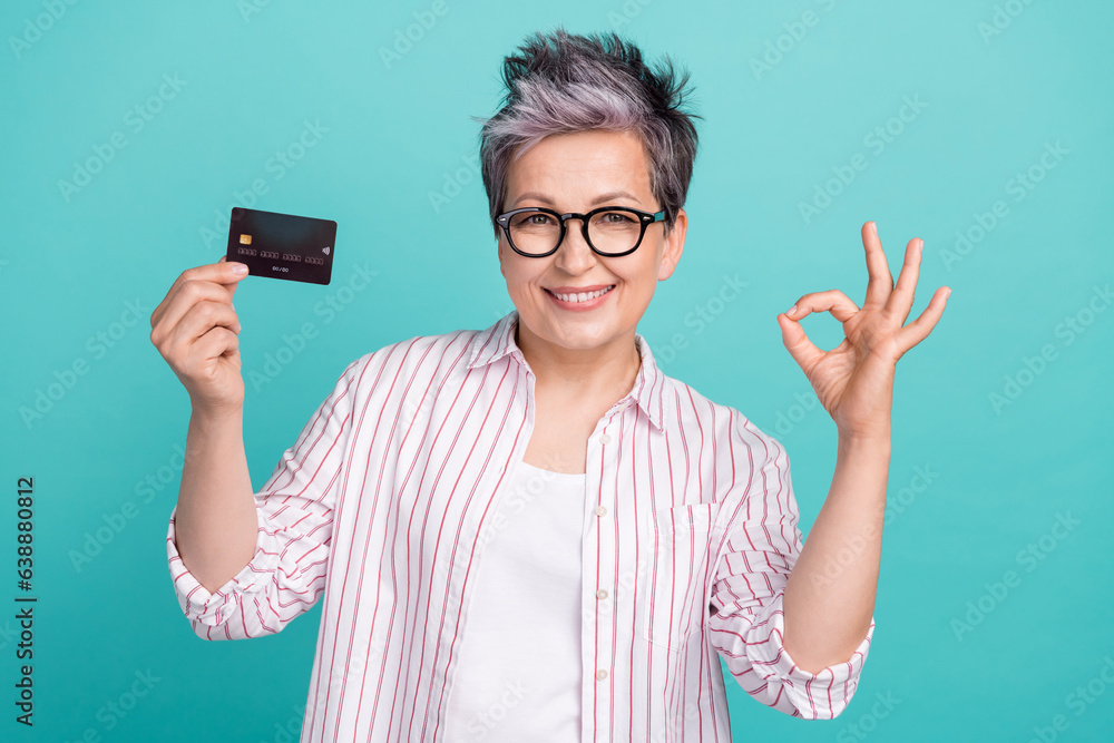 Photo of successful pensioner woman grey dyed haircut show fingers okey sign good job commercial product isolated on cyan color background Photo of successful pensioner woman grey dyed haircut show fingers okey sign good job commercial product isolated on cyan color background