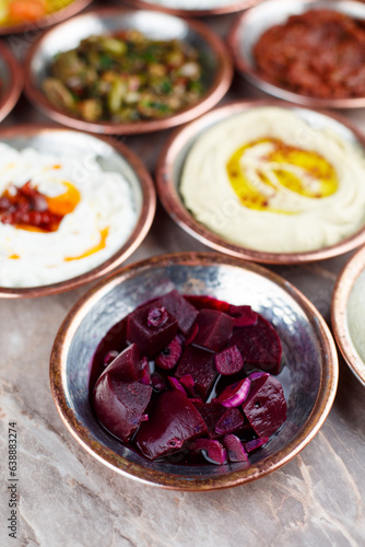 Sweet sugar beet appetizer in a bronze bowl with other appetizers