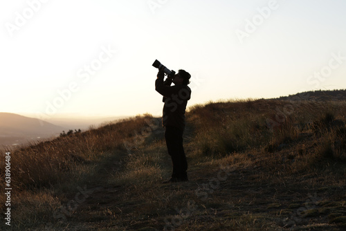 Photograph silhouette of photographer in a sunset in the mountains of Peru. Concept of lifestyles, professions and nature.