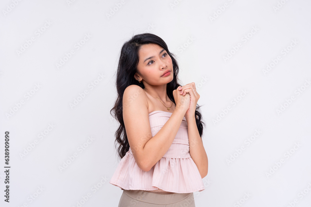 A pretty asian woman with clapsed hands looking up and praying, looking for a fortunate result. Isolated on a white background. A pretty asian woman with clapsed hands looking up and praying, looking for a fortunate result. Isolated on a white background.