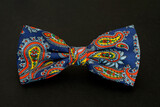 Elegant men's bow tie with floral motifs on a black background.