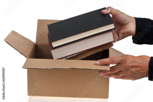 Quelqu'un mettant des livres dans un carton en gros plan sur fond blanc