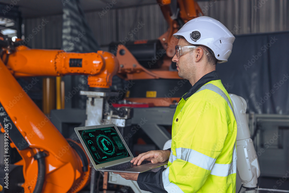 engineer male using laptop computer control operate industry robot arm machine. man programming welding robotic test checking service engineer male using laptop computer control operate industry robot arm machine. man programming welding robotic test checking service