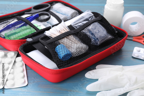 Fotografie First aid kit on blue wooden table, closeup