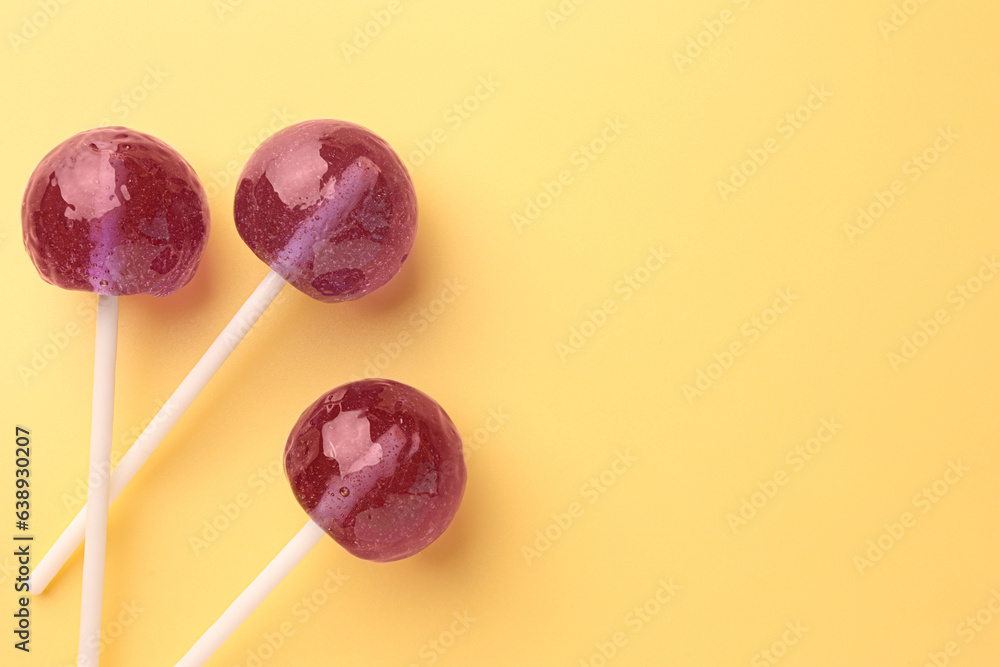 Tasty lollipops on yellow background, flat lay. Space for text Tasty lollipops on yellow background, flat lay. Space for text