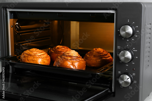 Open electric oven with delicious sweet pastry